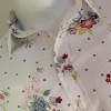 Camicia in cotone linea ARROGANTE, colore bianco con motivi floreali rossi, gialli, verdi e azzurri  - dettaglio frontale torso e collo sul manichino